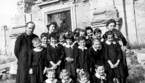Badolo 1950 - Don Tonino con un gruppo di ragazzi davanti ai ruderi della chiesa completamente distrutta durante la seconda guerra mondiale.